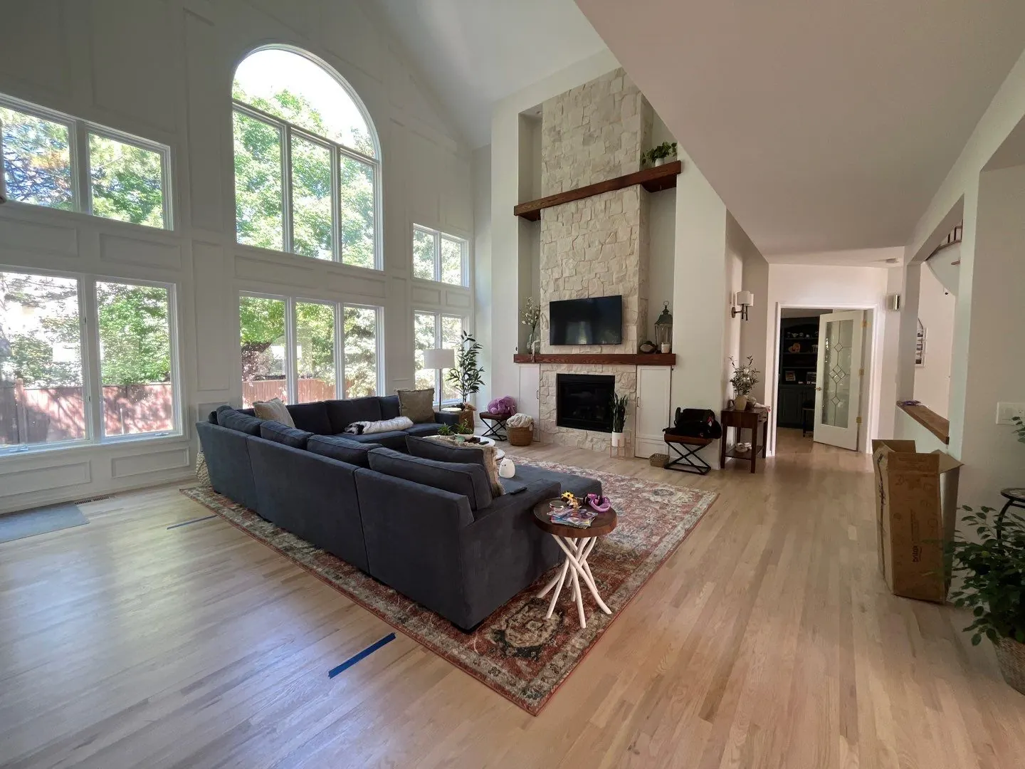 Freshly painted great room with vaulted ceilings, stone fireplace, and white trim