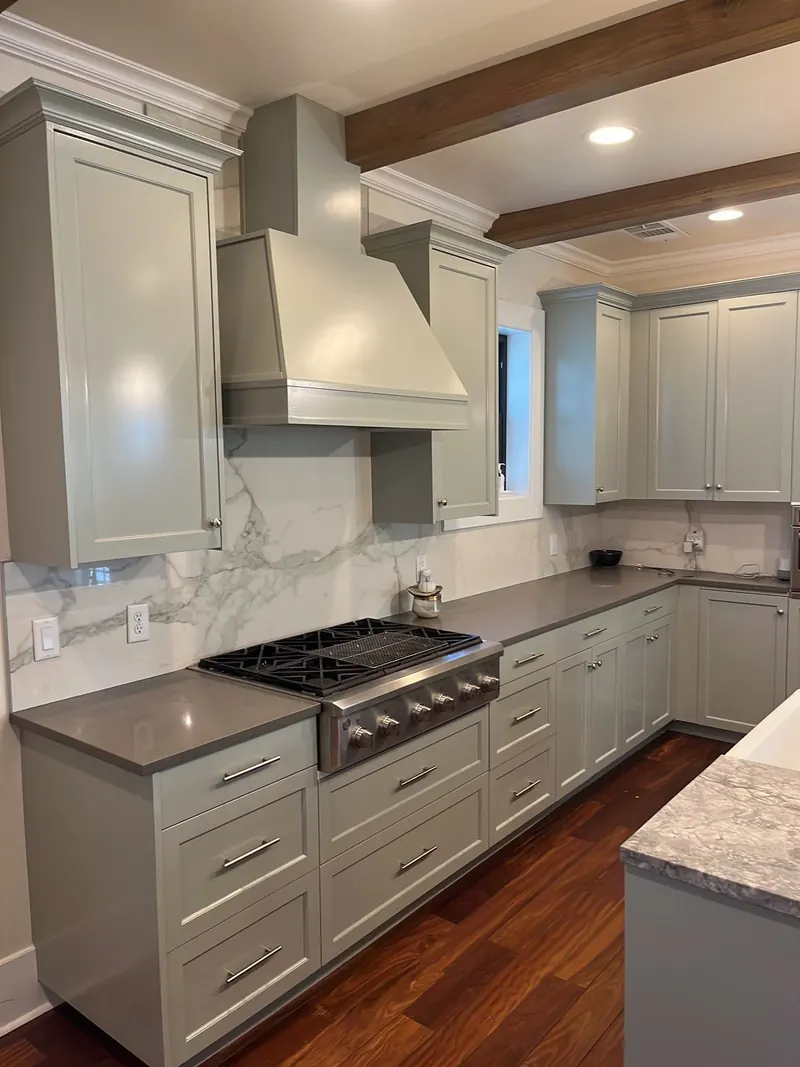 Repainted light gray kitchen cabinets with marble backsplash